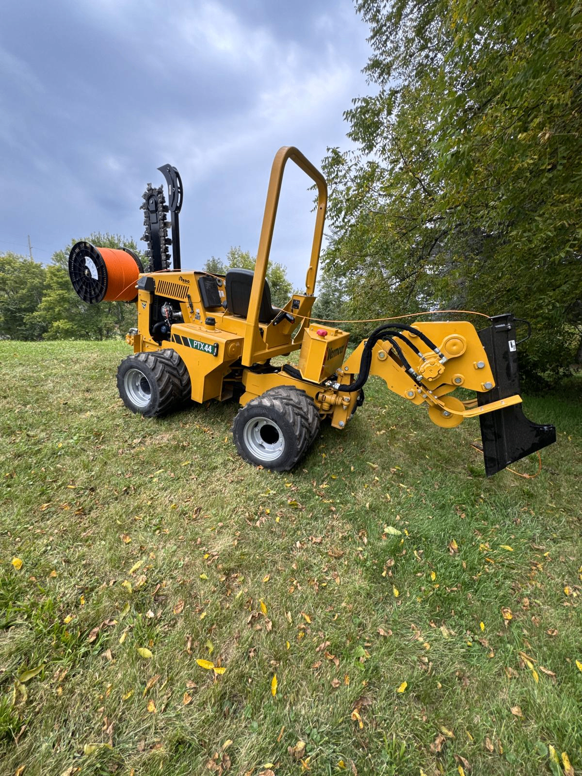 Vermeer PTX44 ride-on trencher with fiber conduit reel on site